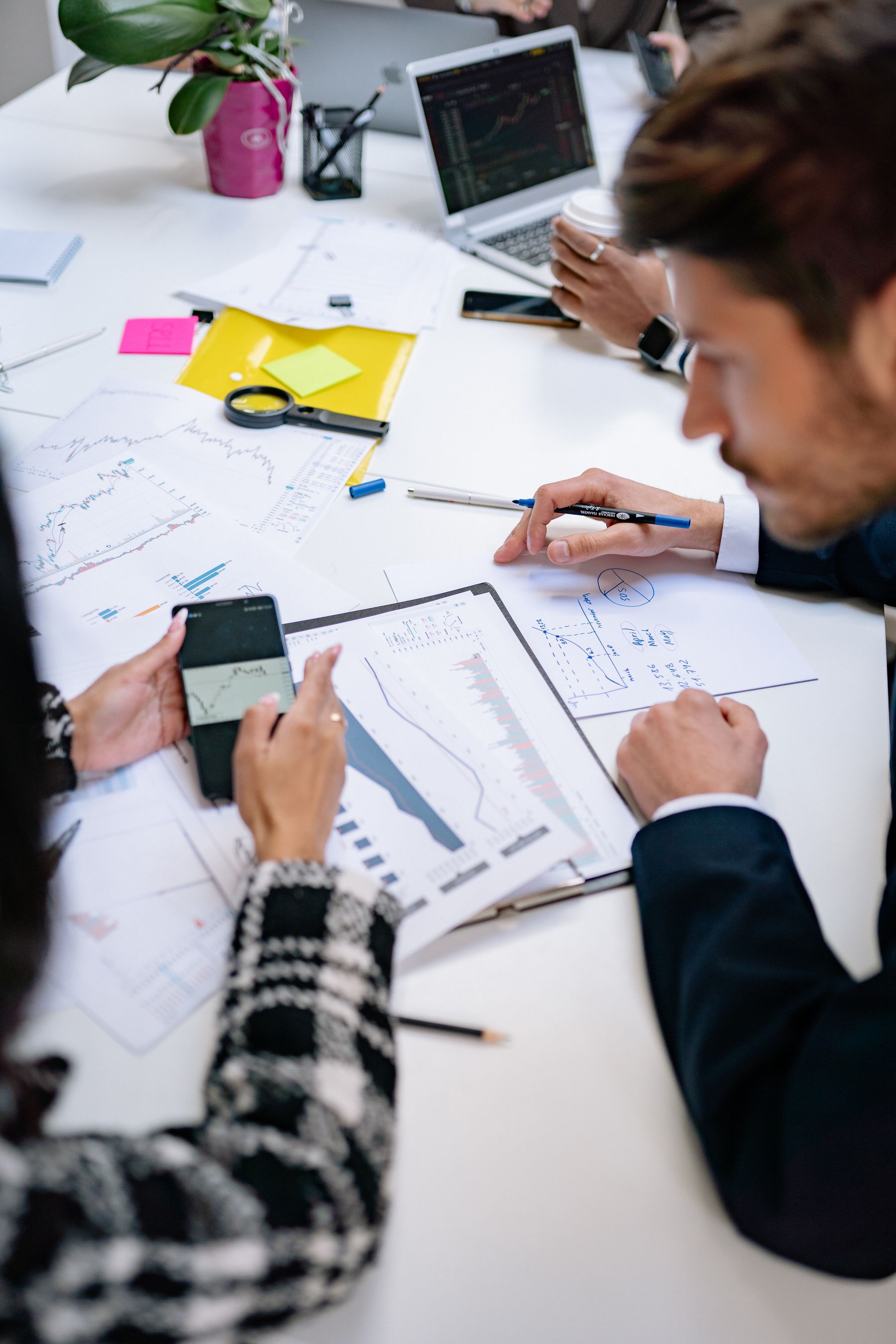 Een gemengd team bespreekt cijfers en documenten rond de werktafel